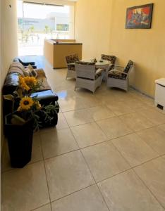 a living room with a couch and chairs and a table at POUSADA DEUS É FIEL Coruripe in Coruripe +2 photos