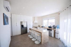 a kitchen with a large counter with stools in it at Villa Redzic Residence in Brca