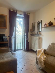 a living room with a couch and a sliding glass door at La casa di Mimo in Nesso
