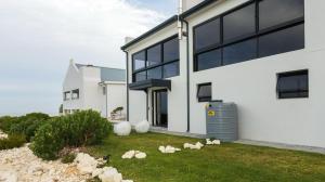 a white house with some animals in the yard at Protea32 in Agulhas +8 photos