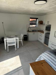 a room with a table and a kitchen with a table and chairs at Protea32 in Agulhas