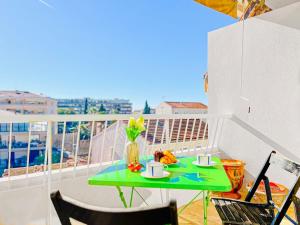 a table on a balcony with a green table and chairs at Cannes Montfleury - Comfortable accommodation Center in Cannes