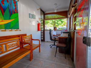 un uomo seduto su una sedia a un tavolo in un ristorante di Pousada do Rei a Ubatuba