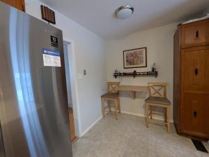 eine Küche mit einem Tisch, 2 Stühlen und einem Kühlschrank in der Unterkunft Bungalow in Green Area in Ottawa