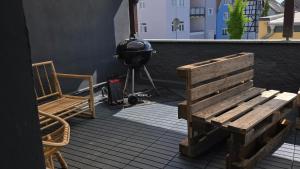 a grill and a wooden bench on a patio at Room 4 - shared house in Linz am Rhein