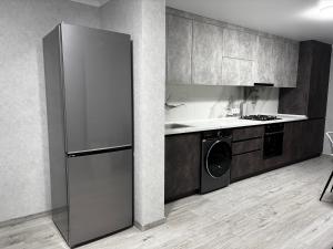 a kitchen with a refrigerator and a washer and dryer at New apartment Căușeni in Căuşeni