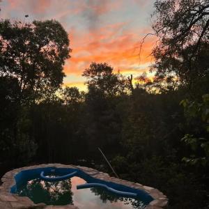 a sunset over a swimming pool in a yard at Refugio de Ángeles in Salsipuedes