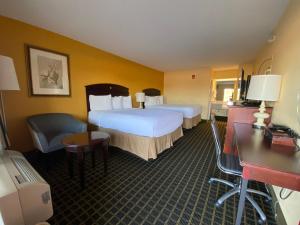 a hotel room with two beds and a desk at Travelinn in Unadilla