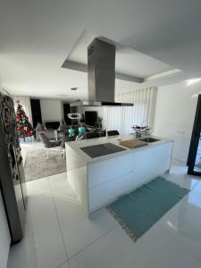 a white kitchen with a counter and a living room at Vila do Sol in Figueiredo