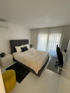 a bedroom with a bed and a chair and a television at Vila do Sol in Figueiredo +14 photos