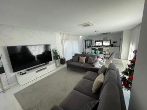a living room with a couch and a television at Vila do Sol in Figueiredo