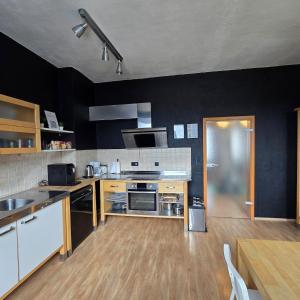 a large kitchen with black walls and wooden floors at Room 3 - shared house in Linz am Rhein +15 photos