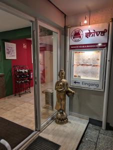 una statua d'oro davanti a un negozio di Hotel Shiva a Maingründel
