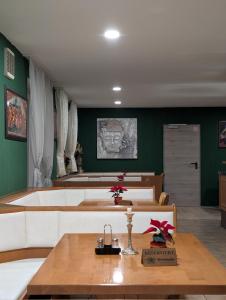 una stanza con pareti verdi, un tavolo e delle panche di Hotel Shiva a Maingründel