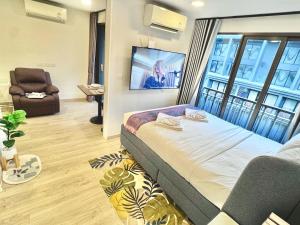 een slaapkamer met een bed, een bank en een tv bij Marvest Lover in Ban Nong Chaeng