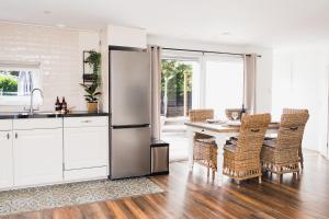 a kitchen with a refrigerator and a table with chairs at Chalet met hottub in Putten