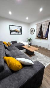 a living room with a black couch with yellow pillows at Kuća za odmor Vista in Slavonski Brod