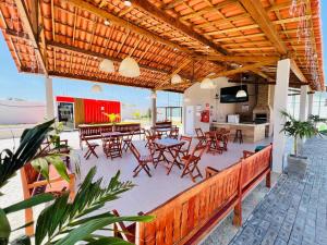a patio with tables and chairs and a kitchen at Casa duplex em condomínio Parnaiba in Parnaíba