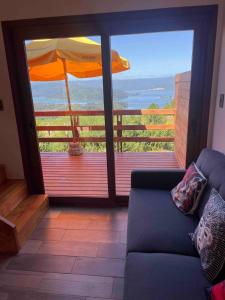 ein Wohnzimmer mit Balkon mit Sonnenschirm in der Unterkunft Loft Valdivia - cutipay in Valdivia