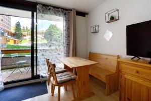 a room with a table and a television and a window at Au pied des pistes (Le Corbier/73) in Villarembert +13 photos