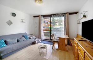 a living room with a couch and a table at Au pied des pistes (Le Corbier/73) in Villarembert