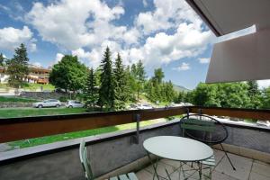 a balcony with two tables and a view of a street at Au pied des pistes (Le Corbier/73) in Villarembert
