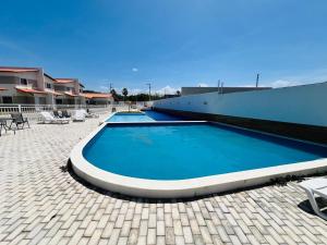 a large blue swimming pool next to a building at Casa duplex em condomínio Parnaiba in Parnaíba