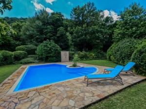een blauw zwembad met twee blauwe stoelen ernaast bij Luxury Green Villa in Boedapest