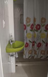 un bagno con lavandino verde e tenda per la doccia di Hostal Paloma Café a Palomino