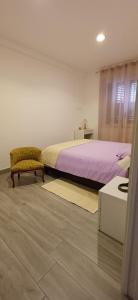 ein Schlafzimmer mit einem Bett, einem Stuhl und einem Tisch in der Unterkunft La Suite del Borgo in Bovalino Marina