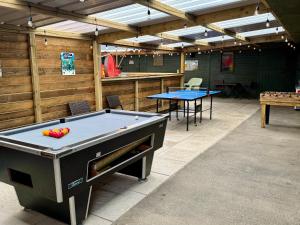 a room with a pool table and two tables at The Beehive in Narberth