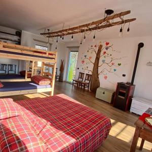 een slaapkamer met stapelbedden en een muurschildering van een boom bij Trekker's Home L'infinito & SPA in Pessinetto