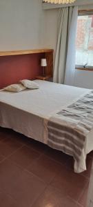 ein großes Bett in einem Zimmer mit Fenster in der Unterkunft Calle 11,2 in Concón