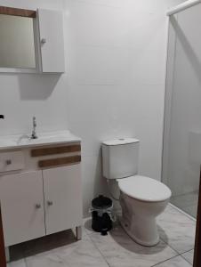 a bathroom with a toilet and a sink and a shower at Aconchego Maria Laura in Palhoça +7 photos
