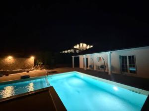 a swimming pool at night in front of a building at Villa Leah in Bihać +11 photos