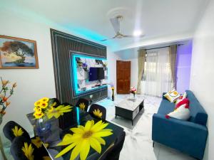 ein Wohnzimmer mit einer blauen Couch und einem Fernseher in der Unterkunft Somerset Apartmento in Tokuse