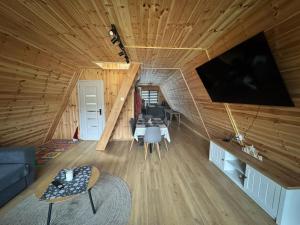 a living room with a couch and a tv in a log cabin at 3A-Chalet-Liban in Liban