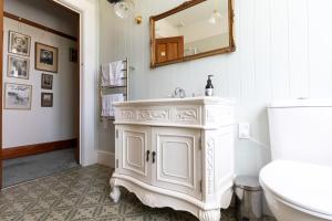 een witte badkamer met een wastafel en een spiegel bij Hemsworth Estate in Elgin