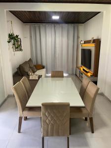 a dining table and chairs in a living room at Casa de Temporada, 2 Quartos com Ar - Prado BA in Prado