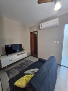 a living room with a blue couch and a flat screen tv at loft climatizado em Timóteo próximo à Aperam, Ipatinga e Coronel Fabriciano in Timóteo