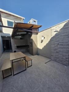 a patio with a table and a bench and a building at loft climatizado próximo à Aperam in Timóteo