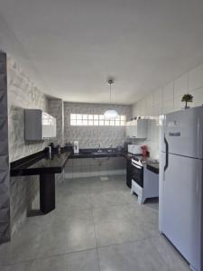 a kitchen with a white refrigerator and a counter at loft climatizado próximo à Aperam in Timóteo