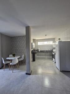 a kitchen and dining room with a table and a refrigerator at loft climatizado próximo à Aperam in Timóteo