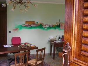 ein Esszimmer mit einem Tisch und einem Zuggemälde an der Wand in der Unterkunft Alisea Eco Residence in Pocapaglia