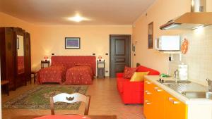 ein Wohnzimmer mit einem roten Sofa und einer Küche in der Unterkunft Alisea Eco Residence in Pocapaglia