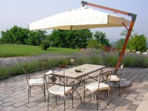 ein Tisch und Stühle unter einem Sonnenschirm auf einer Terrasse in der Unterkunft Alisea Eco Residence in Pocapaglia