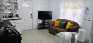 een woonkamer met een bank en een glazen tafel bij Martha's House Audi in Soufrière