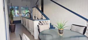 een eetkamer met een glazen tafel en een trap bij Martha's House Audi in Soufrière