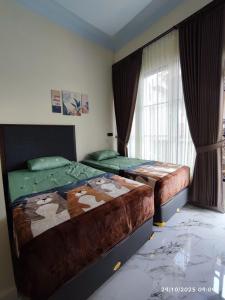 Postel nebo postele na pokoji v ubytování AJA Tumpaksewu Homestay