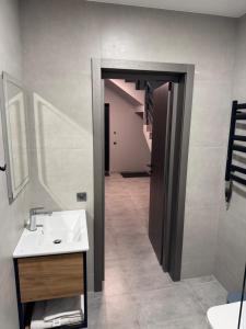 a bathroom with a sink and a mirror and a hallway at cottages GRUN in Yablunytsya +24 photos